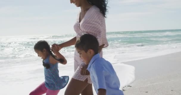 娘と息子のビーチで歩くと幸せなヒスパニック系の母親の中央部 家族の休日自由時間と団結 — ストック動画