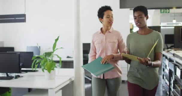 Dos Empresarias Diversas Caminando Oficina Con Documentos Hablando Negocio Creativo — Vídeo de stock