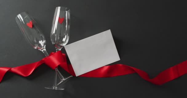 情人节有红心的香槟杯 红丝带和带有复印空间的白卡 情人节 爱与庆祝的概念 — 图库视频影像