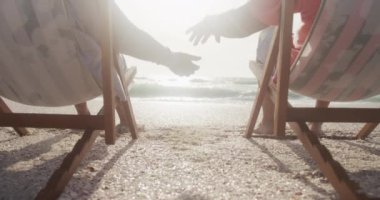 İspanyol kıdemli çiftin gün batımında güneşlenirken el ele tutuşmalarını. Aşk, romantizm ve aktif emeklilik yaşam tarzı.