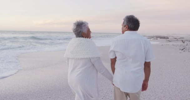 幸せなヒスパニックのバックビューだけで日没時にビーチを歩いてシニアカップルと結婚した 恋愛や結婚の概念を — ストック動画