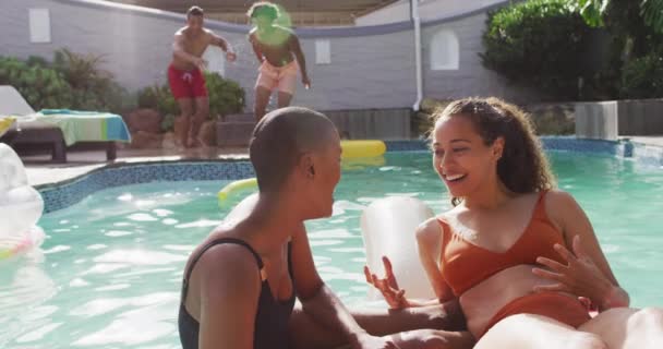 Two Diverse Female Friends Talking Swimming Pool Male Friends Jumping — Vídeo de Stock