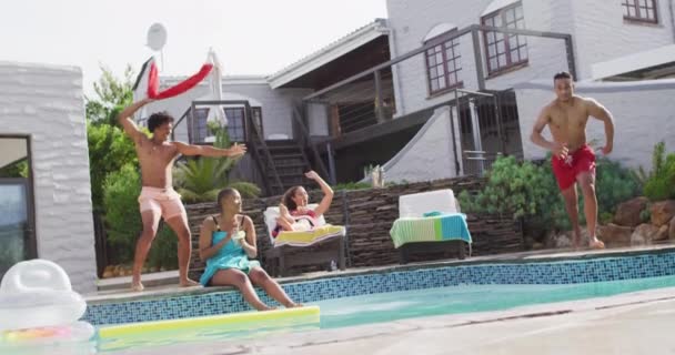 拉丁男人跳进游泳池 和朋友们一起在游泳池派对上大笑 和朋友在家里和花园里玩 — 图库视频影像
