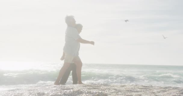 老夫妇手牵着手 在日落时在海滩上散步 看到他那快乐而惊慌的样子 浪漫和退休生活方式 — 图库视频影像