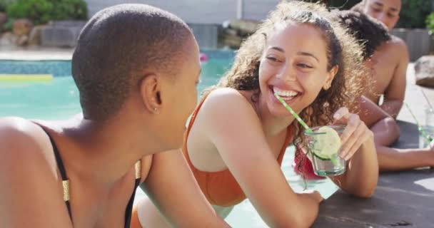 两个快乐的女性朋友在游泳池里笑着喝酒 在泳池派对上和朋友们鬼混 — 图库视频影像