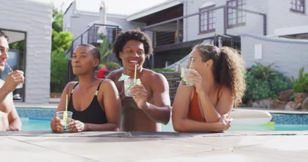 一群多样化的男女朋友 在游泳池里喝着饮料 在泳池派对上和朋友鬼混 — 图库视频影像