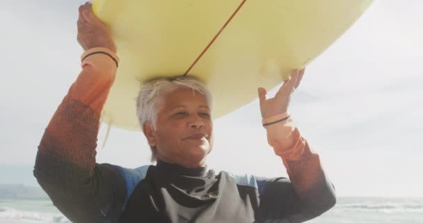 Feliz Mujer Hispana Mayor Caminando Playa Con Tabla Surf Sobre — Vídeo de stock