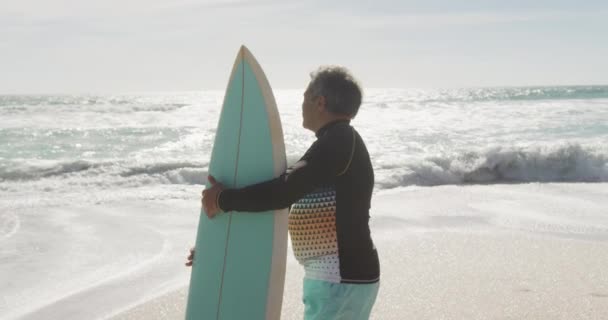 Back View Senior Hispanic Man Standing Beach Surfboard Sporty Healthy — Αρχείο Βίντεο