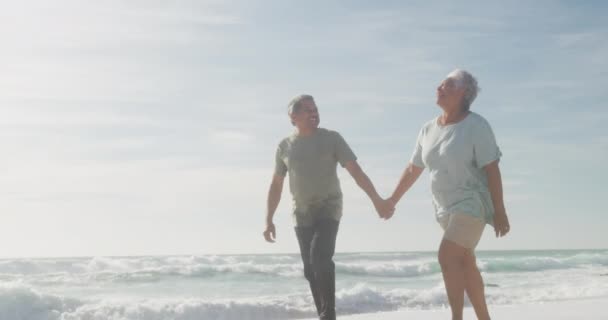 幸せなヒスパニック系のシニアカップルの手を握って ビーチで日没時に歩いてください 愛ロマンス退職生活 — ストック動画