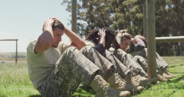 兵士の多様なフィットグループは フィールドでは 太陽の下で軍の障害物コースに座っている 健康的なアクティブライフスタイルブートキャンプで屋外でのクロストレーニング — ストック動画