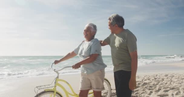 Feliz Pareja Hispana Mayor Caminando Con Bicicletas Playa Atardecer Estilo — Vídeos de Stock