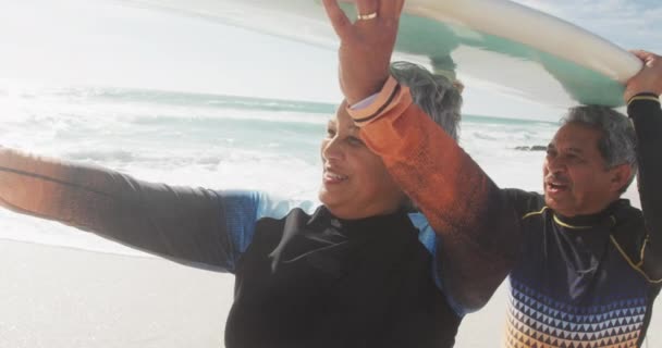 Happy Senior Hispanic Couple Walking Beach Surfboard Heads Sporty Healthy — Stock Video