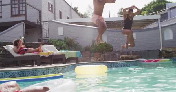 一群快乐多样的男女朋友 在泳池派对上跳进游泳池 和朋友在家里和花园里玩 — 图库视频影像