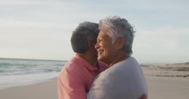 Glückliches hispanisches Seniorenpaar, das bei Sonnenuntergang am Strand tanzt. Liebe, Romantik und aktiver Lebensstil im Ruhestand.