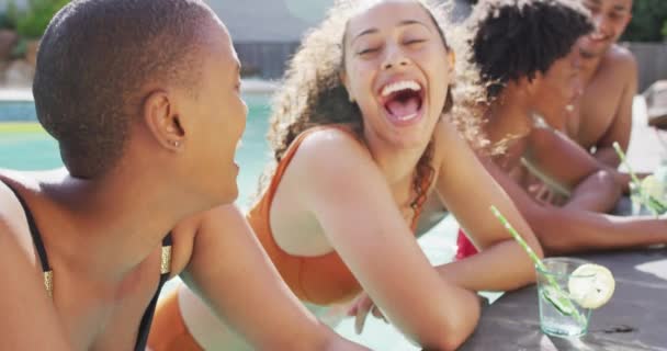 两个不同的女性朋友在游泳池边笑着喝酒 在泳池派对上和朋友鬼混 — 图库视频影像