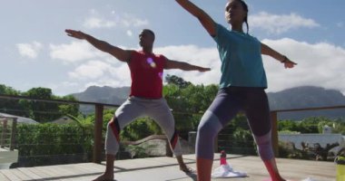 Terasta rahat, çift ırklı bir çift, minderlerde yoga yapıyorlar. Aşk, ilişki ve aktif, sağlıklı yaşam tarzı.