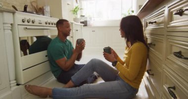 Melez çift mutfakta oturmuş, kahve içip sohbet ediyorlar. Aşk, ilişki ve evde güzel vakit geçirmek..