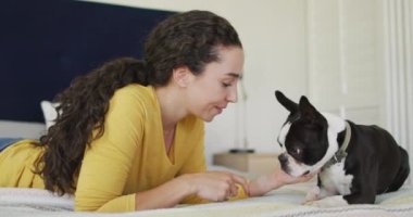 Kafkasyalı kadın evde köpeğiyle oynuyor. Kaliteli boş vakitlerin tadını çıkarıyor..