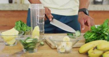 Afro-Amerikan erkeği sağlıklı yeşil smoothie hazırlıyor. sağlıklı aktif yaşam tarzı ve evdeki uygunluk.