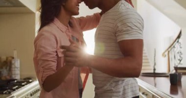 Melez çift mutfakta dans ediyor. Aşk, ilişki ve evde güzel vakit geçirmek..