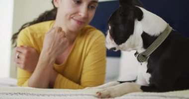 Kafkasyalı kadın evde köpeğiyle oynuyor. Kaliteli boş vakitlerin tadını çıkarıyor..