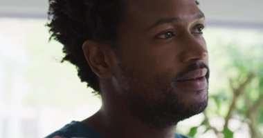 Uzağa bakan düşünceli melez bir adamın portresi. Evde güzel vakit geçirmenin tadını çıkarıyorum. Kaliteli boş vakitlerin tadını çıkarıyor..