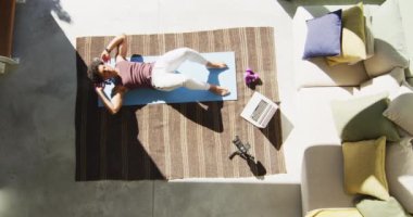 Formda Afro-Amerikan bir adam evde egzersiz yapıyor, mekik çekiyor ve fitness vlog 'u çekiyor. sağlıklı aktif yaşam tarzı ve evdeki uygunluk.