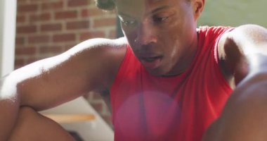 Formda Afro-Amerikan bir adam evde egzersiz yapıyor ve evde yorgun yatıyor. sağlıklı aktif yaşam tarzı ve evdeki uygunluk.