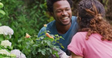 Melez adam elinde güllerle esrar tutuyor, kadın partnerle bahçıvanlık yapıyor. Bahçıvanlık, bahçıvanlık ve bahçe işleri..