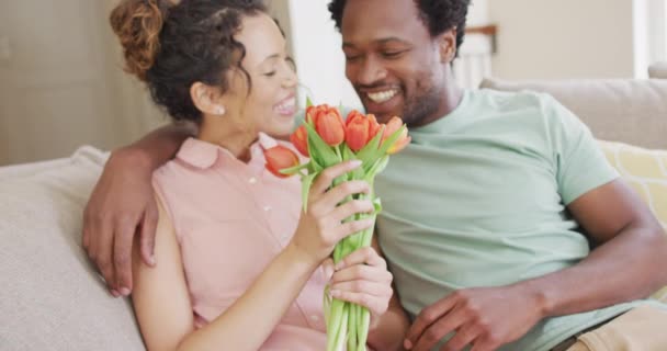 Szczęśliwa Dwurasowa Para Siedząca Kanapie Bukietem Tulipanów Walentynki Romans Uroczystość — Wideo stockowe