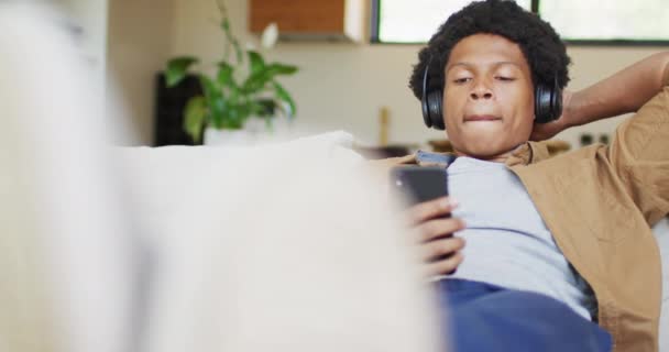 Mutlu Afro Amerikan Adam Evde Akıllı Telefon Kulaklık Kullanıyor Teknoloji — Stok video