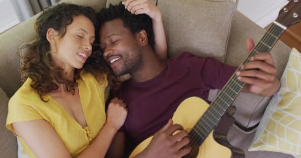 Feliz Pareja Birracial Tumbados Sofá Juntos Tocando Guitarra Amor Relación — Vídeos de Stock