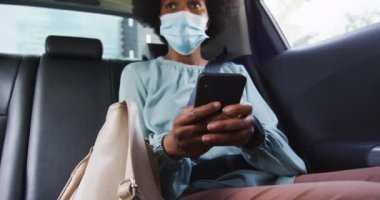 Akıllı telefon kullanan Afrika kökenli Amerikalı iş kadını. Dijital göçebe covid 19 salgını sırasında şehirde dolanıyor..
