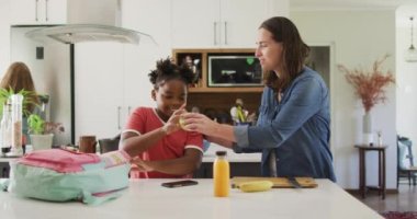 Kafkasyalı mutlu kadın ve Afrikalı Amerikalı kızı birlikte yemek paketliyor. ev hayatı, evde zaman geçirmek..