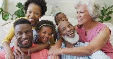 Afro-Amerikan ailesinin oturma odasında kucaklaşan mutlu portresi. Aile evde birlikte vakit geçiriyor..
