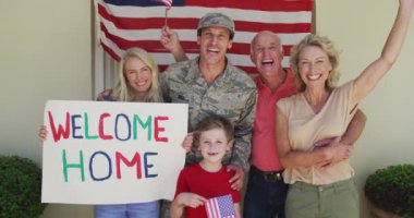 Beyaz erkek askerin portresi, gülümseyen ailesini Amerikan bayrağı üzerinde kucaklıyor. Asker evine, ailesine dönüyor..