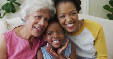 Yetişkin kızı ve torunu olan mutlu bir Afrikalı Amerikalı büyükannenin portresi. Aile evde birlikte vakit geçiriyor..