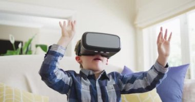 Caucasian boy waving hands and talking during playing with vr headset. spending time alone at home.