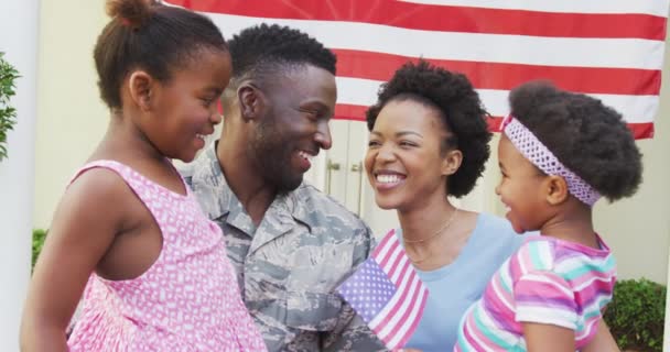 非裔美国士兵拥抱他微笑的家人 高举美国国旗 回家的士兵 — 图库视频影像
