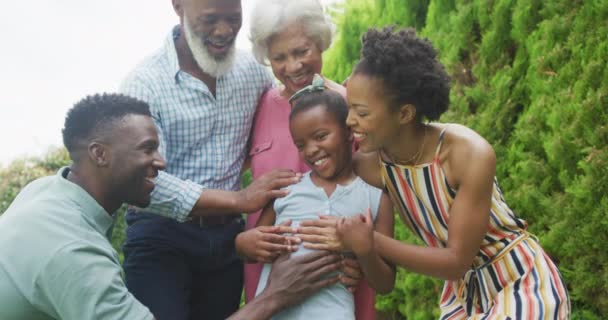 庭で抱擁し 笑顔幸せなアフリカ系アメリカ人の家族の肖像画 家族で屋外で過ごす時間 — ストック動画