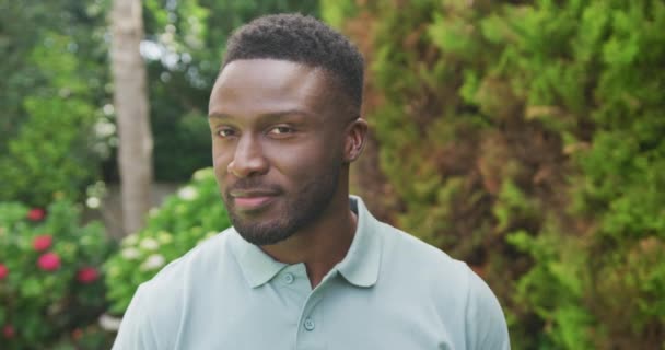 Πορτρέτο Του Χαμογελαστού Αφροαμερικανού Που Κοιτάζει Την Κάμερα Στον Κήπο — Αρχείο Βίντεο