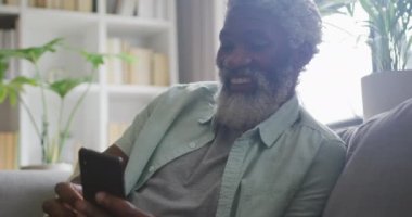 Akıllı telefon kullanan Afrikalı son sınıf öğrencisinin videosu. Emeklilik yaşam tarzı, ev konseptinde dijital olarak oluşturulmuş video ile zaman geçirme.