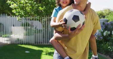 Bahçede futbol oynayan mutlu melez adamın ve oğlunun portresi. ev hayatı, evde zaman geçirmek..