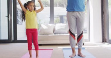 Mutlu çift ırklı baba-kız yoga yapıyor, birlikte meditasyon yapıyor. ev hayatı, evde boş zaman geçirmek..