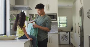 Mutlu çift ırklı baba-kız okul için öğle yemeği hazırlıyor. ev hayatı, evde boş zaman geçirmek..