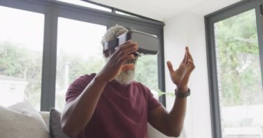 VR kulaklık kullanan Afro-Amerikan son sınıf öğrencisinin videosu. Emeklilik yaşam tarzı, ev konseptinde dijital olarak oluşturulmuş video ile zaman geçirme.