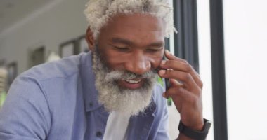 Akıllı telefon kullanan Afrikalı son sınıf öğrencisinin videosu. Emeklilik yaşam tarzı, ev konseptinde dijital olarak oluşturulmuş video ile zaman geçirme.
