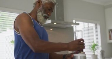 Afrika asıllı Amerikalı son sınıf öğrencisinin smoothie hazırlarken videosu. Emeklilik yaşam tarzı, ev konseptinde dijital olarak oluşturulmuş video ile zaman geçirme.