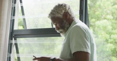 Akıllı telefon kullanan Afrikalı son sınıf öğrencisinin videosu. Emeklilik yaşam tarzı, ev konseptinde dijital olarak oluşturulmuş video ile zaman geçirme.