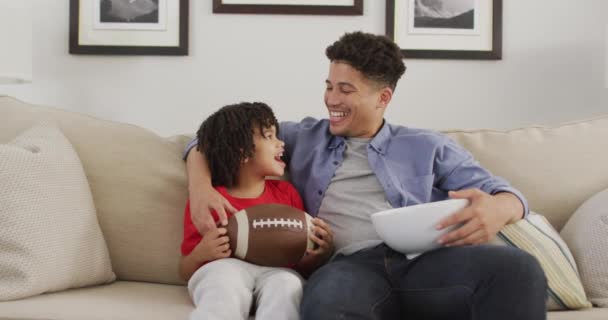 Szczęśliwy Dwurasowy Człowiek Jego Syn Oglądają Razem Mecz Futbolu Amerykańskiego — Wideo stockowe